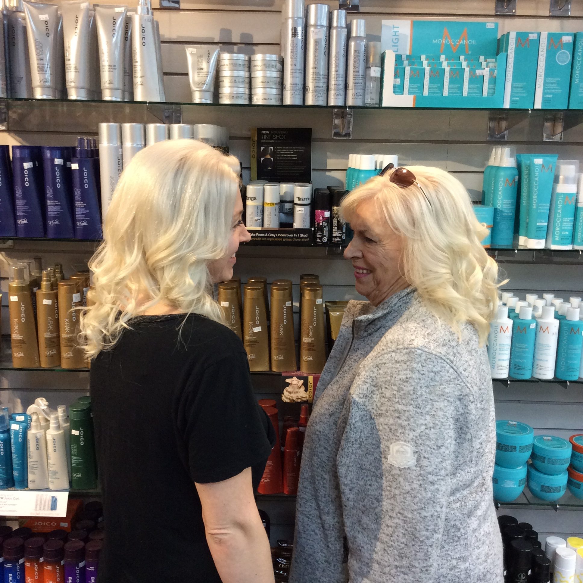 Two matching blondes standing side by side at hairstyle inn